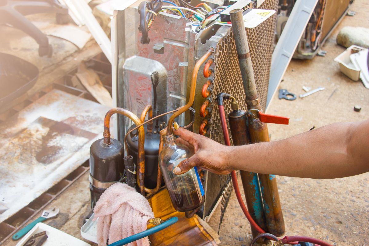 A worker doing maintenance on the small parts of the indsutrial chiller