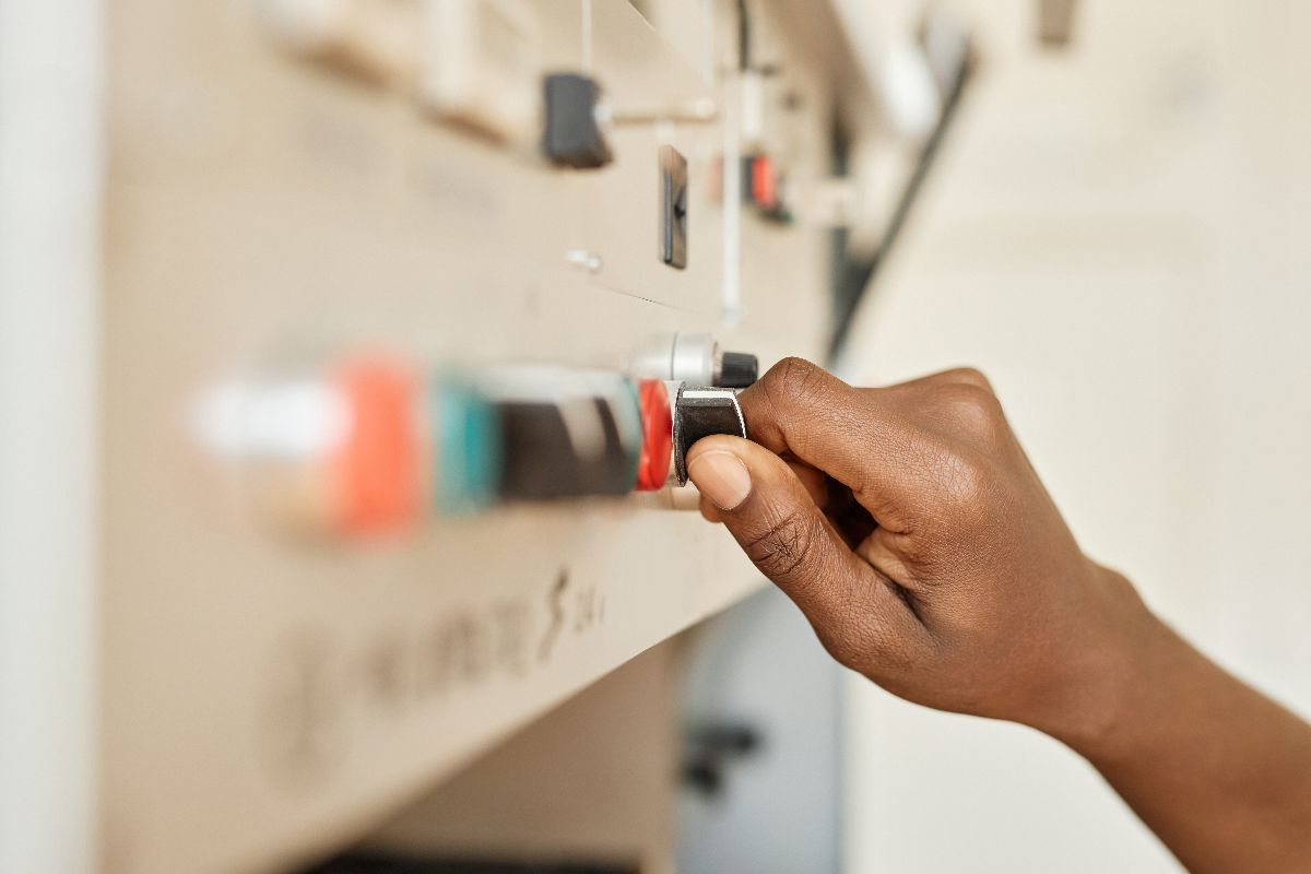 A man switching off the control panel at a factory
